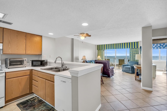 5806 N Ocean Blvd Unit 203, North Myrtle Beach, SC 29582 - kitchen featuring white dishwasher, black microwave, a sink, a peninsula, and a textured ceiling