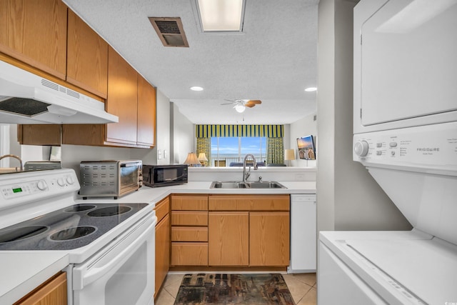 5806 N Ocean Blvd Unit 203, North Myrtle Beach, SC 29582 - kitchen featuring white appliances, under cabinet range hood, stacked washer / dryer, a sink, and light tile patterned floors