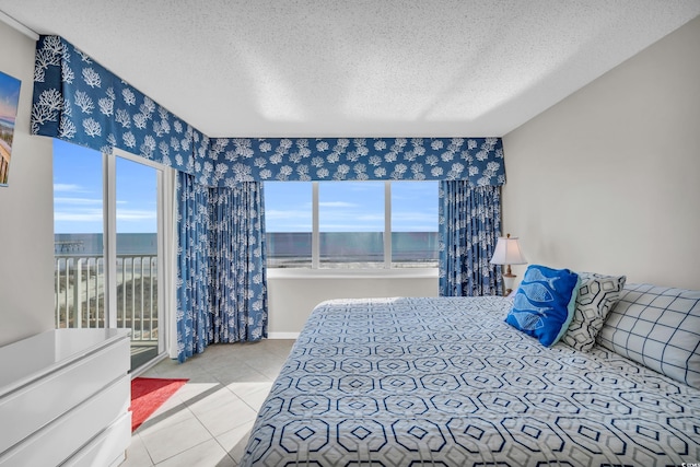 5806 N Ocean Blvd Unit 203, North Myrtle Beach, SC 29582 - bedroom featuring a textured ceiling, tile patterned floors, access to exterior, and a water view