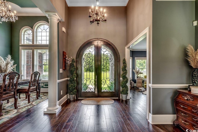 foyer entrance with a chandelier, baseboards, plenty of natural light, a high ceiling, and crown molding