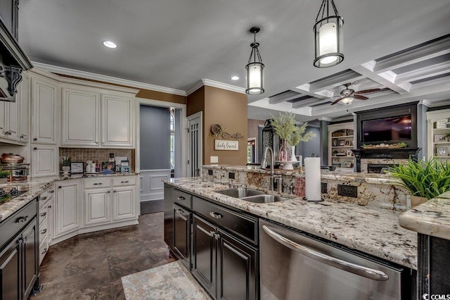 kitchen with a sink, dishwasher, crown molding, ceiling fan, and a fireplace