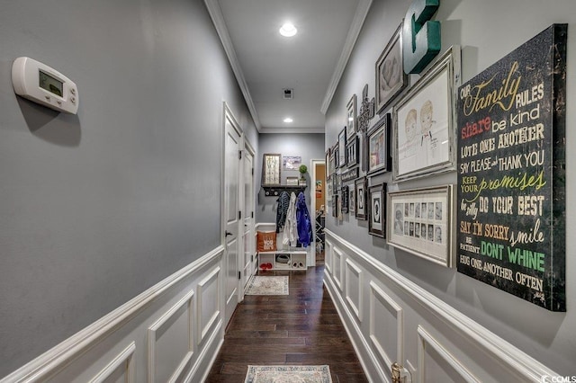 corridor featuring crown molding, a decorative wall, dark wood-type flooring, a wainscoted wall, and recessed lighting