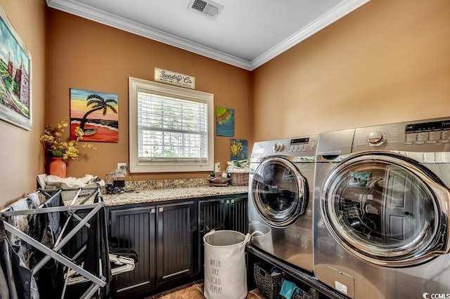 clothes washing area featuring crown molding and washing machine and dryer