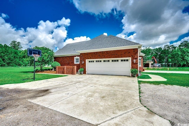 view of side of property with a yard, brick siding, an attached garage, driveway, and roof with shingles