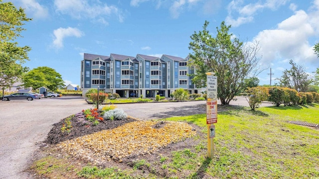 view of apartment building / complex featuring uncovered parking