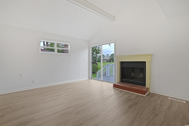 unfurnished living room with beamed ceiling, light wood-style flooring, baseboards, high vaulted ceiling, and a fireplace