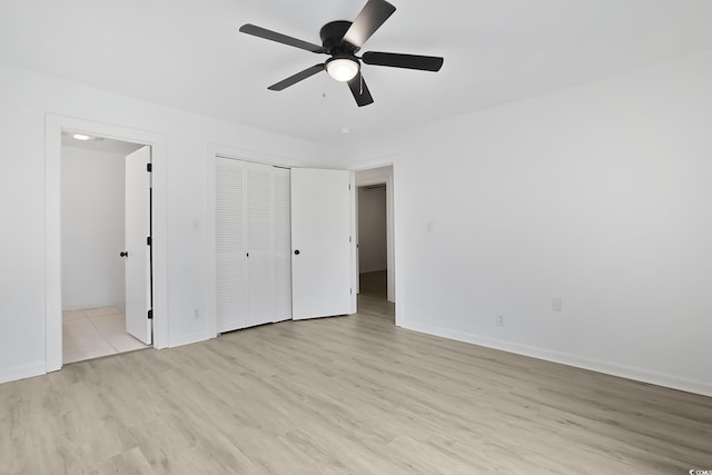 unfurnished bedroom with light wood-style floors, baseboards, ceiling fan, and a closet