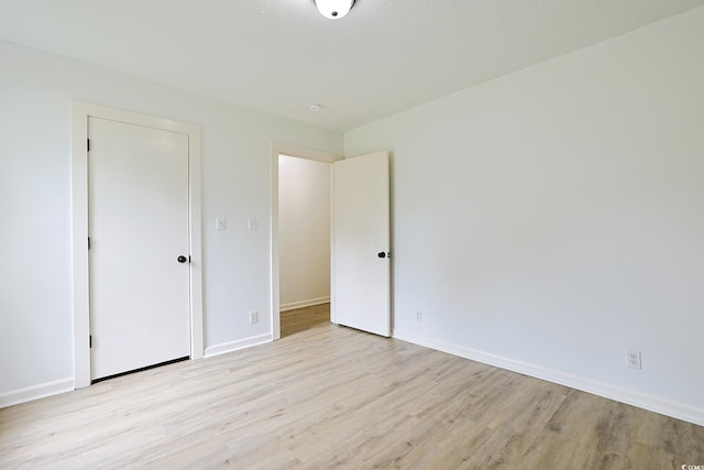 unfurnished bedroom with light wood-style flooring and baseboards