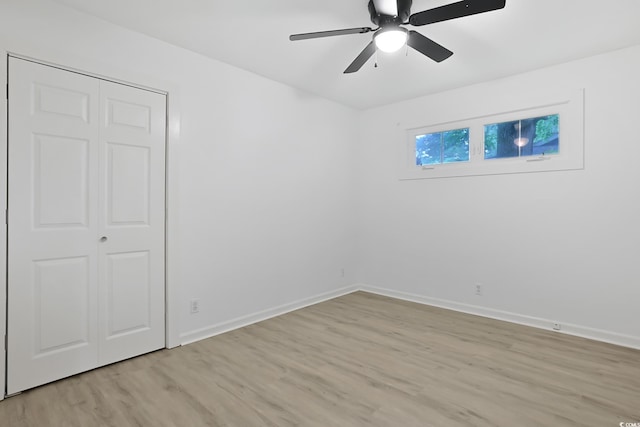 unfurnished bedroom with light wood-style flooring, baseboards, and ceiling fan