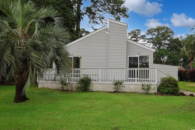 view of home's exterior featuring a deck, a yard, and a chimney