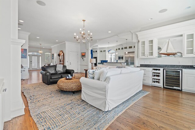 107 Waterway Crossing Ct, Little River, SC 29566 - living room with wine cooler, a chandelier, ornate columns, light wood-style floors, and recessed lighting
