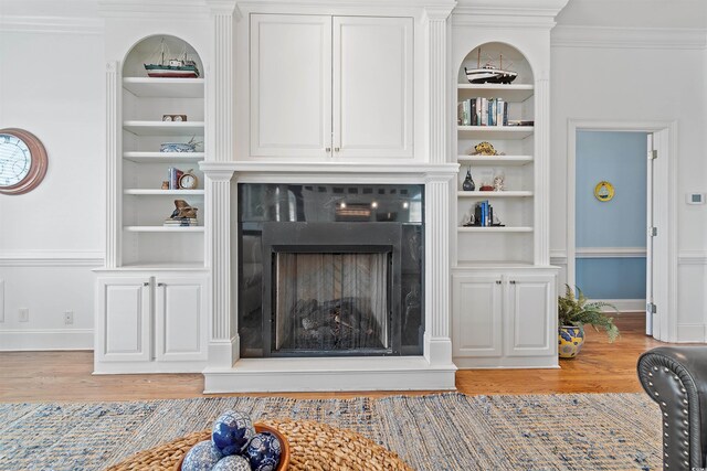 107 Waterway Crossing Ct, Little River, SC 29566 - living area featuring built in features, light wood-type flooring, a fireplace with raised hearth, baseboards, and ornamental molding