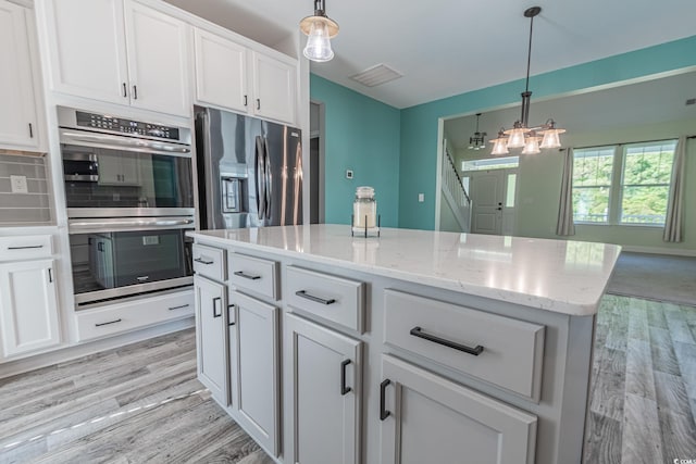 395 Dunbarton Ln, Conway, SC 29526 - kitchen with stainless steel appliances, light wood finished floors, white cabinetry, and pendant lighting