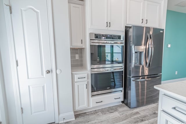 395 Dunbarton Ln, Conway, SC 29526 - kitchen featuring appliances with stainless steel finishes, white cabinets, tasteful backsplash, and light wood-style flooring