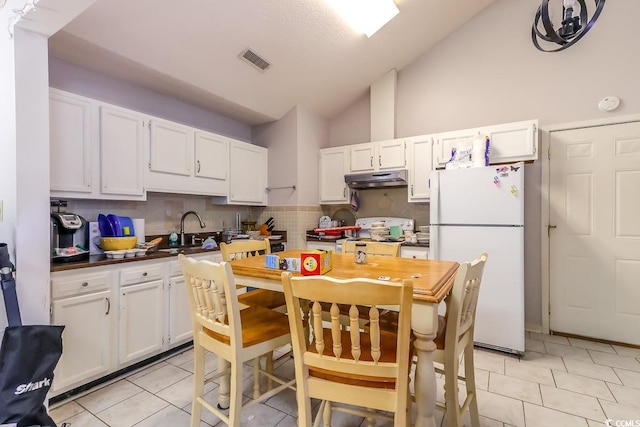 9664 Middleton Ct, Murrells Inlet, SC 29576 - kitchen with freestanding refrigerator, stove, under cabinet range hood, a sink, and white cabinetry