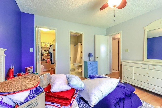 9664 Middleton Ct, Murrells Inlet, SC 29576 - bedroom with a walk in closet, connected bathroom, wood finished floors, ceiling fan, and a textured ceiling