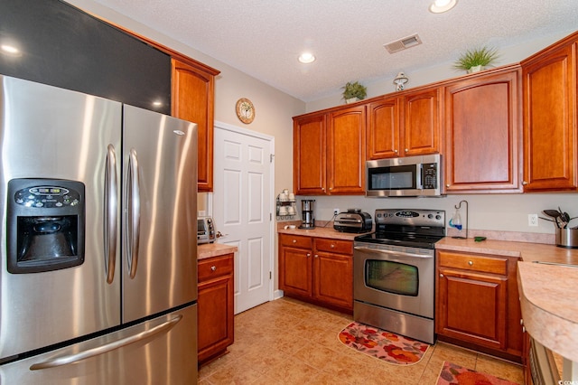 111 Rose Water Loop, Myrtle Beach, SC 29588 - kitchen featuring stainless steel appliances, light countertops, recessed lighting, brown cabinets, and a textured ceiling