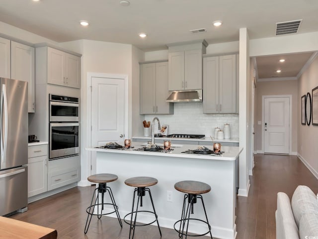 4861 Hopespring St, Myrtle Beach, SC 29579 - kitchen with stainless steel appliances, under cabinet range hood, a kitchen bar, light countertops, and crown molding