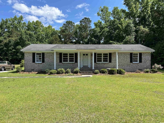 view of front of property featuring brick siding, a front yard, and crawl space
