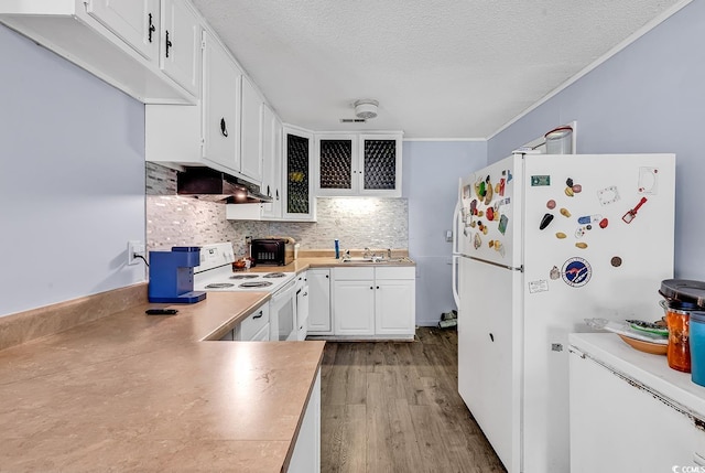 kitchen with white appliances, light wood-type flooring, white cabinets, under cabinet range hood, and backsplash