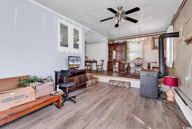office area with a ceiling fan, a baseboard heating unit, wood finished floors, a textured ceiling, and a chandelier
