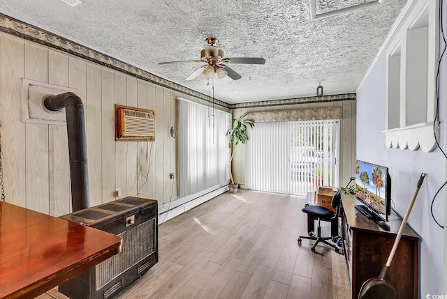 home office featuring ceiling fan, baseboard heating, wood finished floors, a wall unit AC, and wooden walls