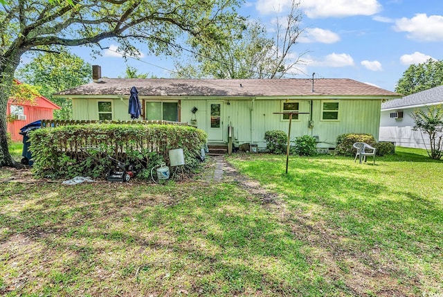 back of house featuring a yard, a chimney, and entry steps