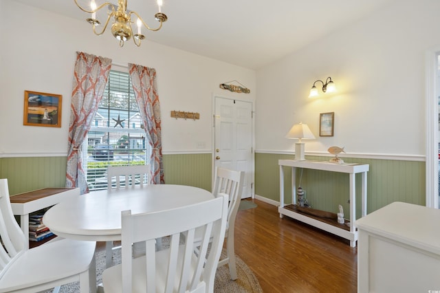 dining room featuring a wainscoted wall, a chandelier, and wood finished floors