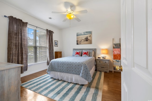 bedroom with baseboards, wood finished floors, and a ceiling fan