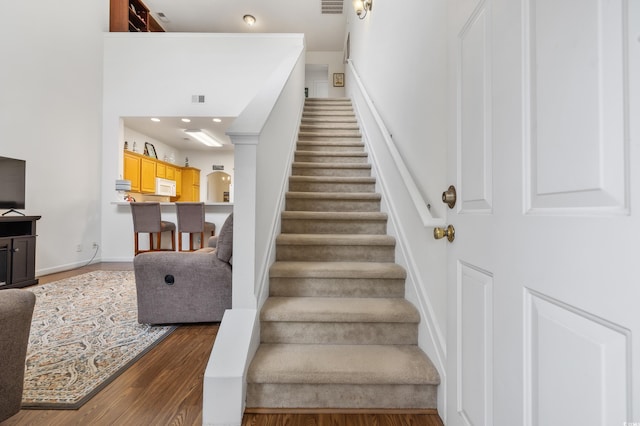 stairs with wood finished floors and baseboards