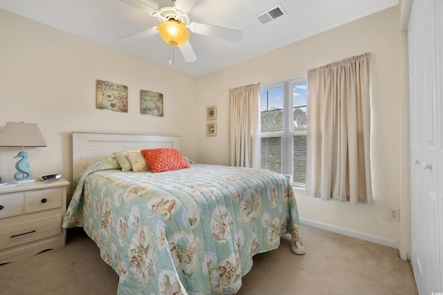 bedroom featuring light colored carpet, baseboards, and a ceiling fan