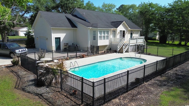 rear view of property featuring an attached garage, a shingled roof, stairway, and a wooden deck
