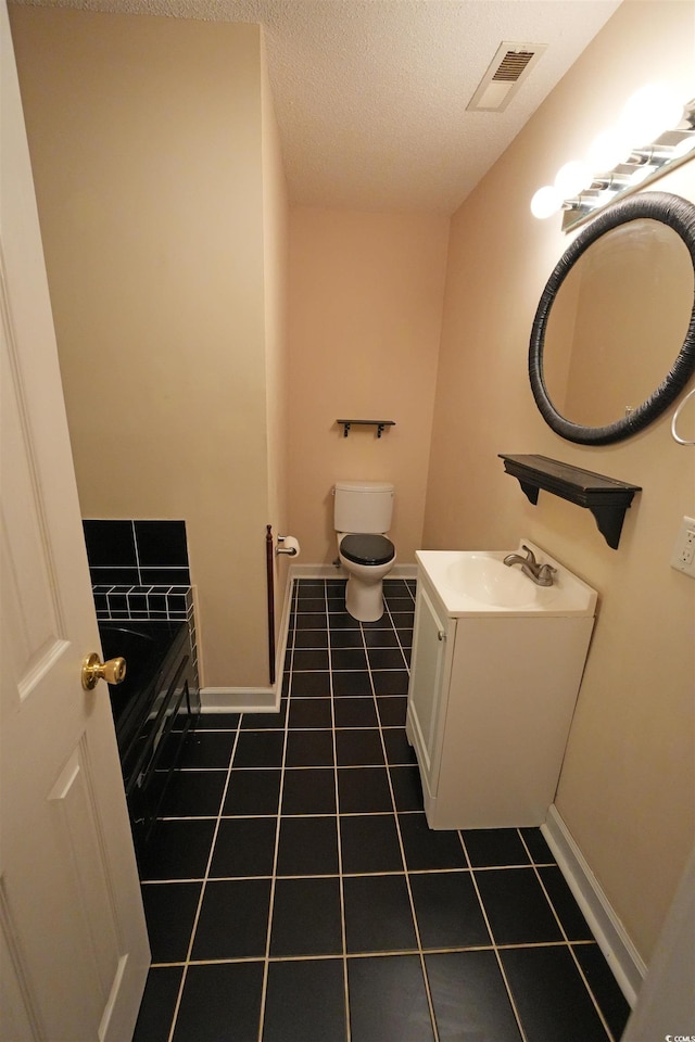 bathroom featuring tile patterned floors, toilet, baseboards, a textured ceiling, and vanity