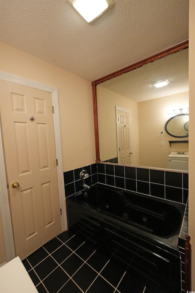 bathroom featuring tile patterned flooring, a whirlpool tub, and a textured ceiling