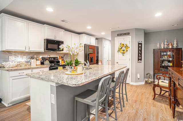 2016 Willow Run Dr Unit B, Little River, SC 29566 - kitchen featuring black appliances, light wood-type flooring, white cabinets, baseboards, and recessed lighting
