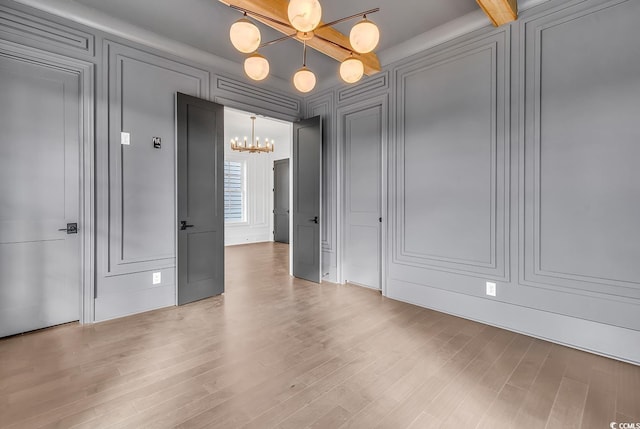 437 Saint Julian Ln, Myrtle Beach, SC 29579 - spare room with a decorative wall, a chandelier, and wood finished floors