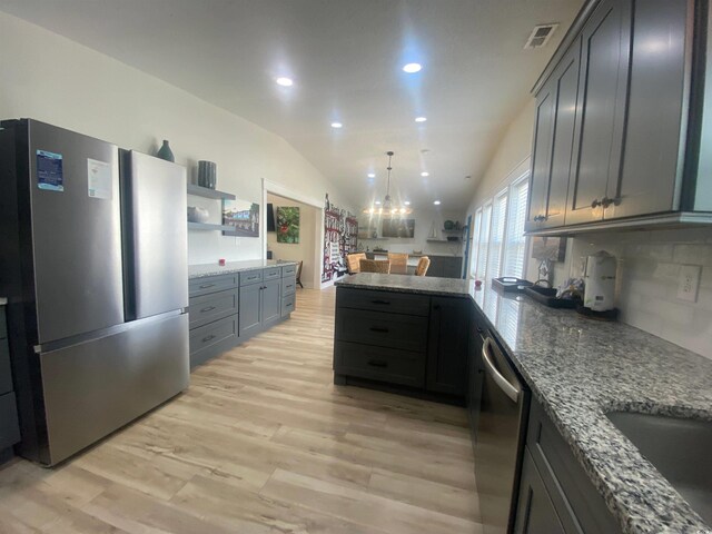 6205 Nixon St, North Myrtle Beach, SC 29582 - kitchen featuring appliances with stainless steel finishes, a peninsula, light stone countertops, light wood finished floors, and recessed lighting
