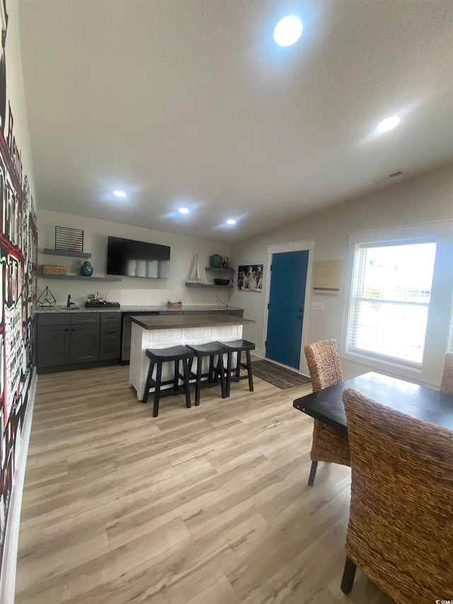6205 Nixon St, North Myrtle Beach, SC 29582 - kitchen with light wood-style floors, a textured ceiling, open shelves, recessed lighting, and a breakfast bar