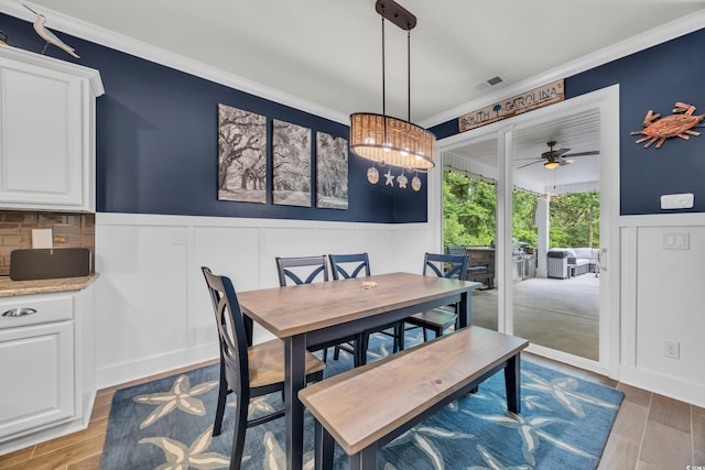 1009 Oak Marsh Ln, North Myrtle Beach, SC 29582 - dining room featuring ornamental molding, a wainscoted wall, a decorative wall, light wood finished floors, and a chandelier