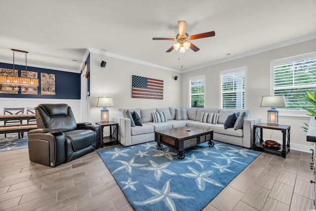 living room with wood tiled floors, plenty of natural light, ornamental molding, a ceiling fan, and a wainscoted wall