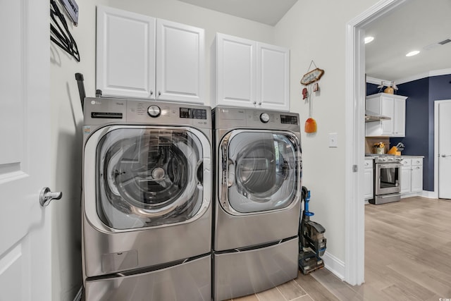 washroom with cabinet space, washing machine and clothes dryer, light wood-style flooring, baseboards, and recessed lighting