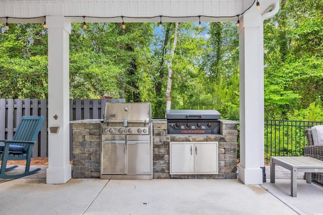 view of patio / terrace featuring a grill, area for grilling, and fence