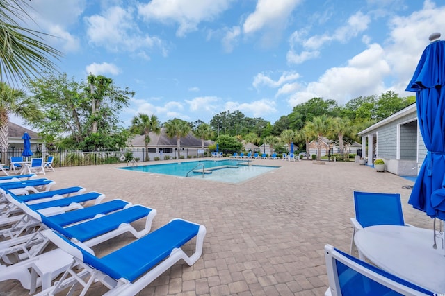 community pool featuring fence and a patio