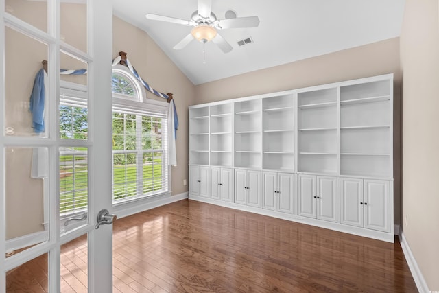 empty room with lofted ceiling, wood finished floors, baseboards, and ceiling fan