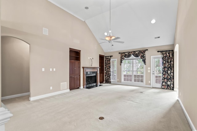 1315 Cherry Dr, Surfside Beach, SC 29575 - unfurnished living room with a fireplace with flush hearth, light colored carpet, high vaulted ceiling, ceiling fan, and arched walkways