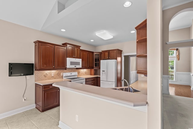 kitchen with white appliances, a sink, open shelves, a peninsula, and backsplash