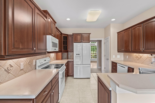 kitchen with white appliances, a sink, tasteful backsplash, light countertops, and recessed lighting