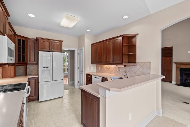 kitchen with white appliances, a sink, backsplash, light countertops, and recessed lighting