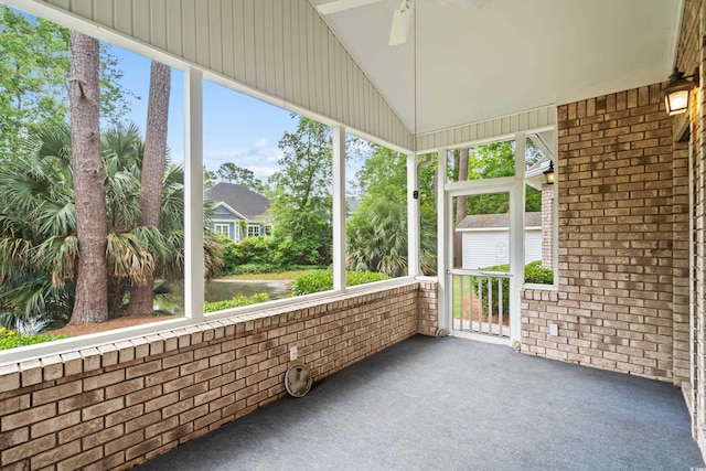 unfurnished sunroom with a ceiling fan and lofted ceiling