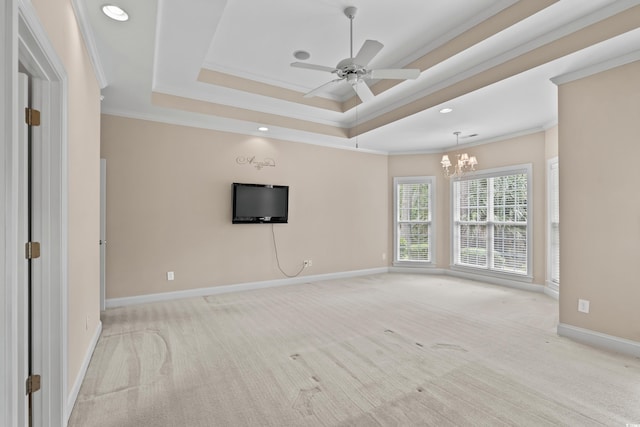unfurnished living room with crown molding, carpet floors, a chandelier, baseboards, and a tray ceiling